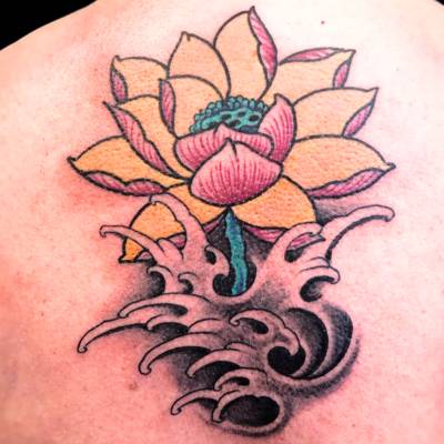 Tatuaje flor de loto tradicional con olas estudio de tatuajes en Zaragoza Barbarroja Tattoo